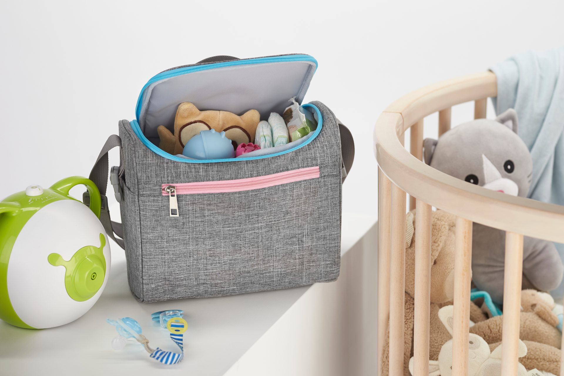 Nosiboo Bag Baby Organizer on a shelf next to the baby cot bed and filled with baby accessories