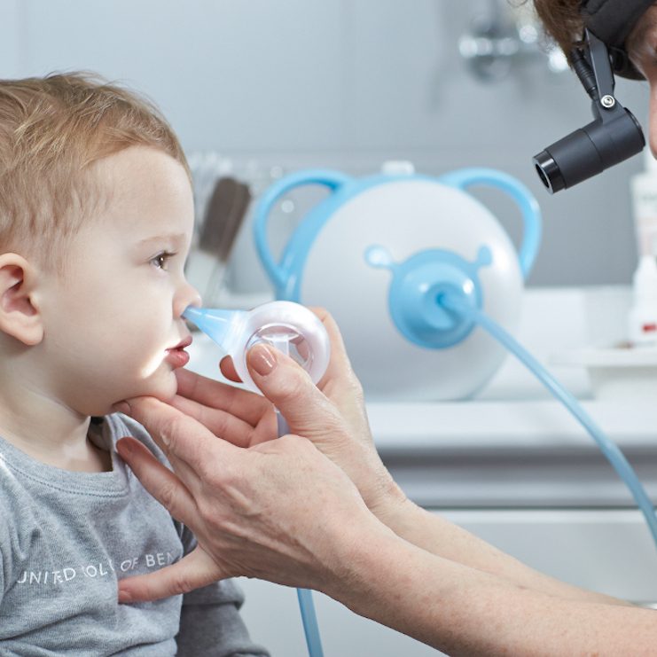 Egy fül-orr-gégész tisztítja egy kisfiú orrát a Nosiboo Pro elektromos orrszívó segítségével.