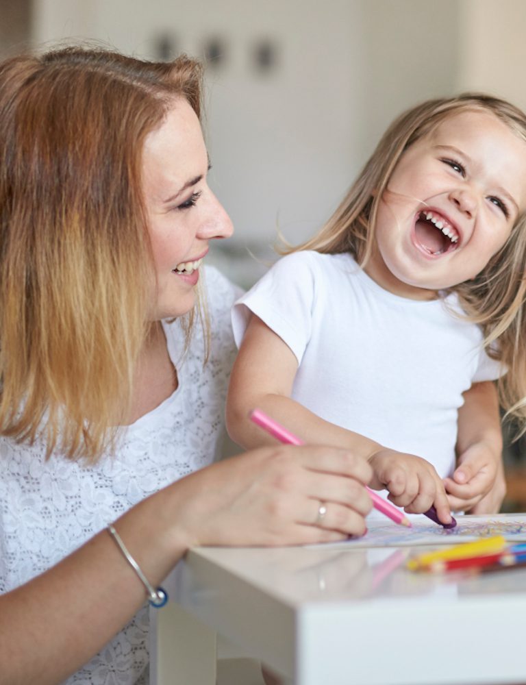 Eine Mutter und ihre kleine Tochter zeichnen glücklich und spielfreudig zusammen